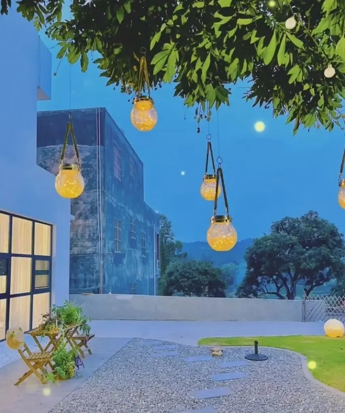 Đi qua cổng gỗ là sân vườn rộng lớn với bãi cỏ, lối đi lát đá và nhiều loại cây cỏ và hoa. Ảnh: Sohu