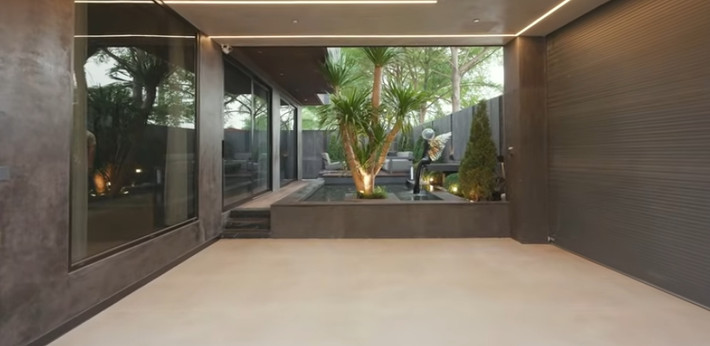 Căn biệt thự 4 tầng nằm trên khu đất 186m2, diện tích xây dựng một sàn 100m2. Tầng 1 gồm gara ô tô và một sân vườn. Ảnh chụp màn hình NhaTo