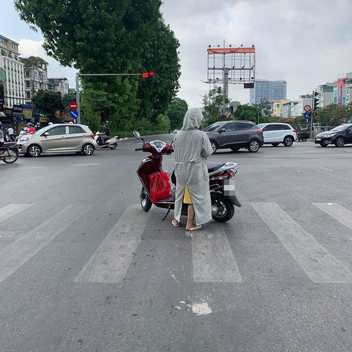Hình ảnh người phụ nữ dừng đèn đỏ chẳng giống ai, trơ trọi giữa hai bên đường không một bóng xe cộ khiến nhiều người ngao ngán.