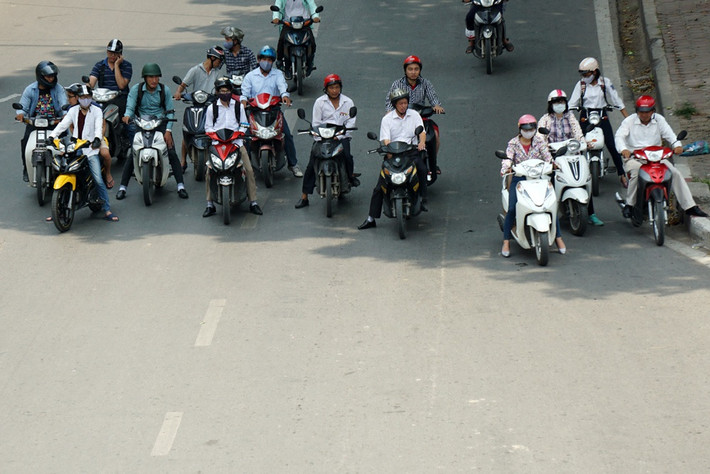 Nhiều phương tiện xe máy khi dừng đèn đỏ đã chọn giải pháp đứng dưới bóng cây, cách vạch kẻ quy định chờ đèn đỏ cả chục mét.