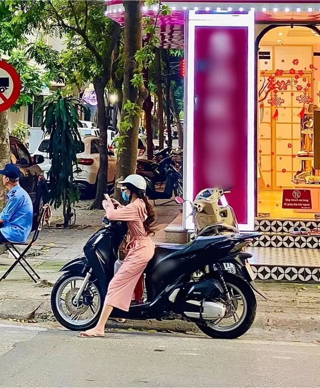 Sau đó khi đèn chuyển sang tín hiệu xanh được di chuyển, cô gái có chiều cao khiêm tốn mới từ từ lên xe và điều khiển xe máy chạy tiếp.