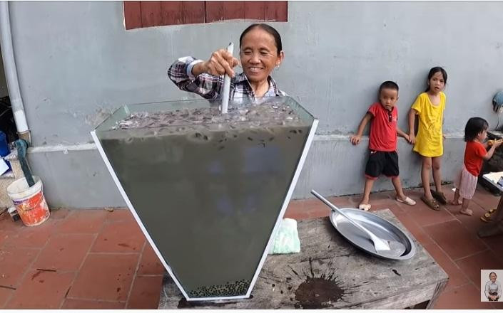 Bà Tân trộn hỗn lộn các nguyên liệu tạo nên một thùng "xi măng" khủng lồ.