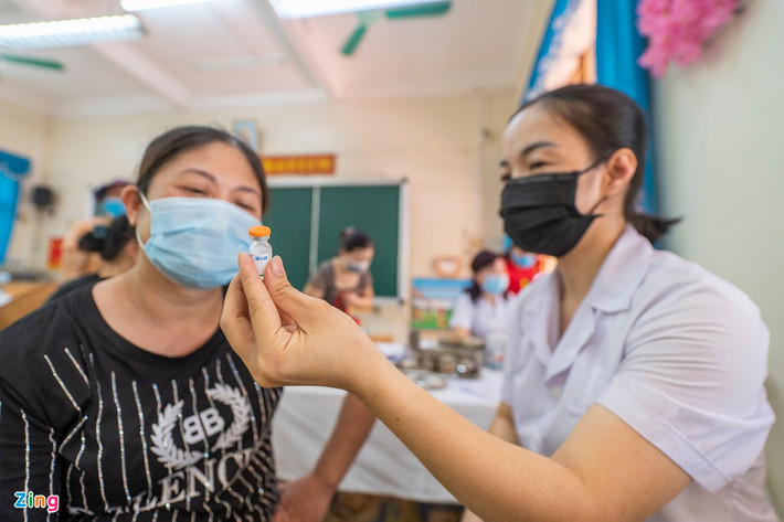 Trước khi tiêm, cán bộ y tế giới thiệu về chủng loại, nguồn gốc xuất xứ của vắc xin cho người dân.