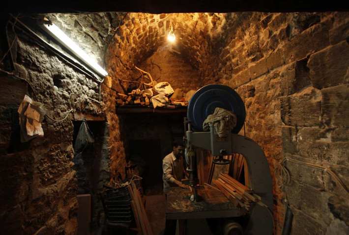 Thợ mộc đang xẻ gỗ trong xưởng ở Aleppo.