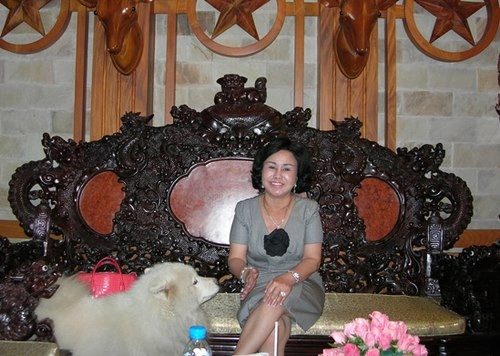 Bà Diệu Hiền bên bộ ghế gỗ hoành tráng, đắt tiền tại căn biệt thự.
