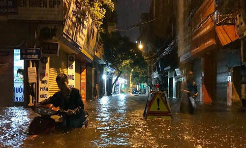 Trận mưa lớn trút xuống thủ đô kèm theo nhiều tiếng sấm sét lúc 19h15 tối 12/5 biến nhiều khu vực ở Hà Nội thành "sông". Trong ảnh là phố Hoa Bằng, quận Cầu Giấy.