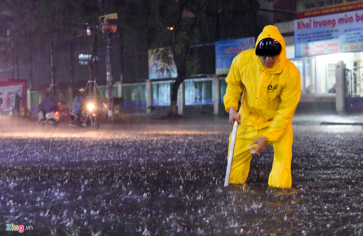 Công nhân thoát nước có mặt kịp thời dọn rác trôi làm tắc cống nhưng do cơn mưa lớn, phố Thái Hà vẫn bị ngập sâu trong vài giờ.