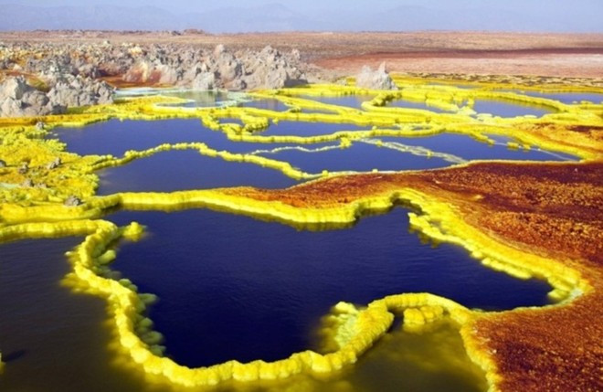 Dallol, Ethiopia: Khu vực ngay gần núi lửa đã ngừng hoạt động trong thời gian qua và là nơi sở hữu nhiệt độ khủng khiếp với mức trung bình hơn 41 độ C trong suốt gần 100 năm qua. Ngoài ra, Màu sắc tươi sáng và rực rỡ xuất hiện xung quanh khu vực miệng núi lửa như màu trắng, vàng, đất son, xanh lá cây và đỏ là do có sự kết hợp của những con suối nước nóng, núi lưu huỳnh, hồ axit, hồ oxit sắt, lớp muối ẩn. Không ngạc nhiên khi gần như không có người ở tại đây.