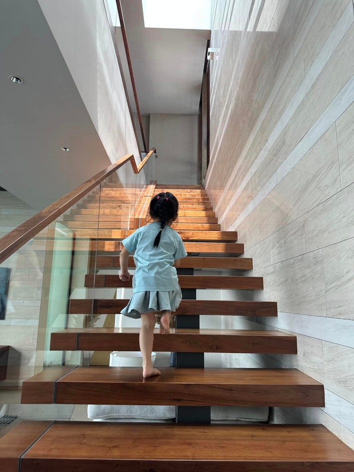 Cầu thang gỗ lan can kính hiện đại.