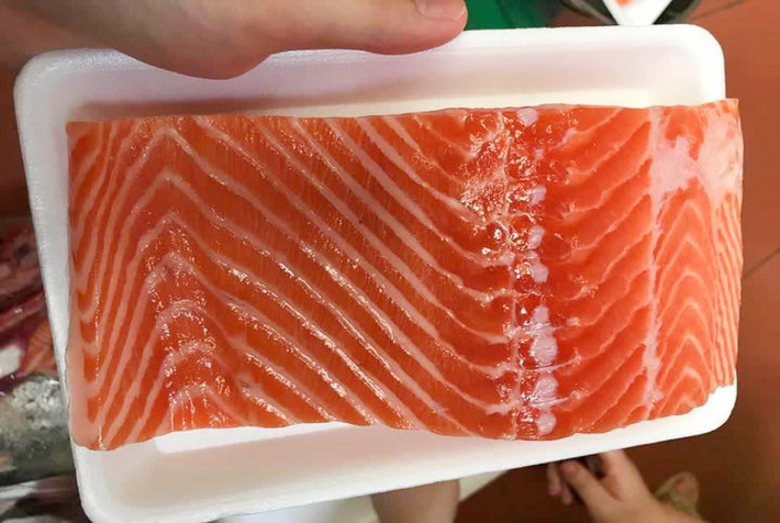 Nhiều khả năng cá hồi cắt khúc nhập khẩu giá rẻ như vậy có thể do hạn sử dụng gần hết hoặc để quá lâu không tiêu thụ được. Vì vậy, người tiêu dùng cần lưu ý cách chọn cá hồi tươi ngon để không bị mua phải hàng kém chất lượng. Ảnh: Facebook.