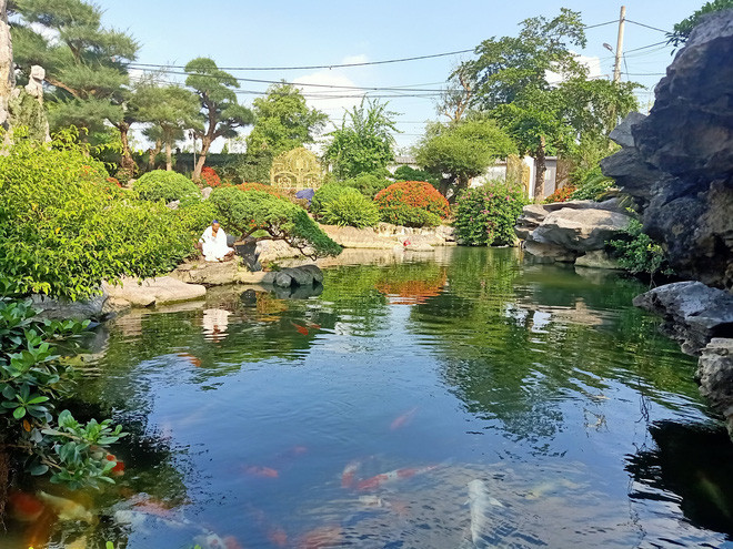 Căn biệt thự 2 tầng sơn trắng có khu nhà phụ và một nhà lầu nằm trong khuôn viên rộng với rất nhiều tiểu cảnh, hồ cá...Ảnh: Khắc Thành