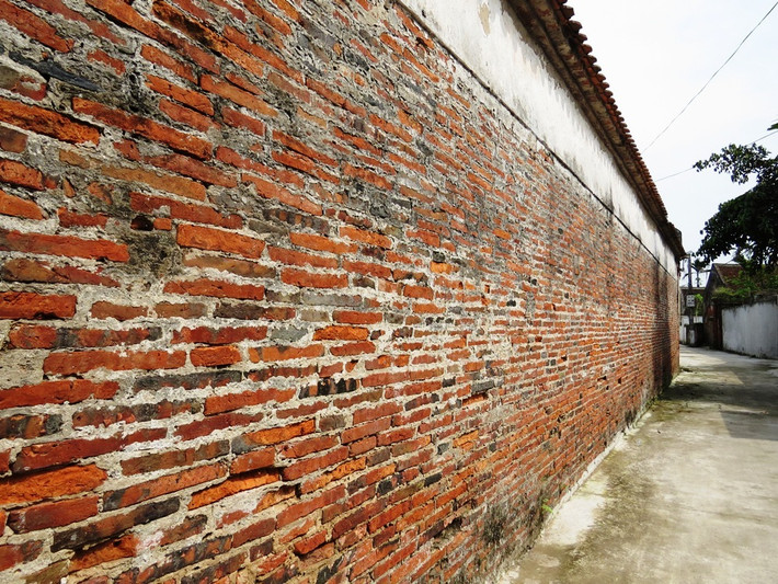 Tường nhà được xây bằng gạch đất nung bản mỏng, kích thước mỗi viên gạch dài tới 40 cm, rộng ngang 30 cm. Ảnh: Vnexpress.
