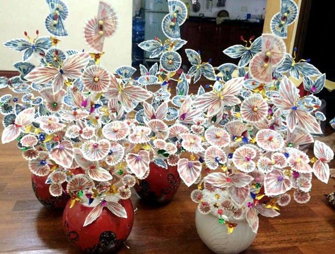 Cây tiền tài lộc được làm bằng tiền bằng tiền thật với các mệnh giá nhỏ 500 - 10.000 đồng khá hút khách mỗi dịp Tết đến. Những người trang trí cây tiền được trả từ 300.000 - 600.00 đồng/cây tùy loại. Ảnh: Lao động.
