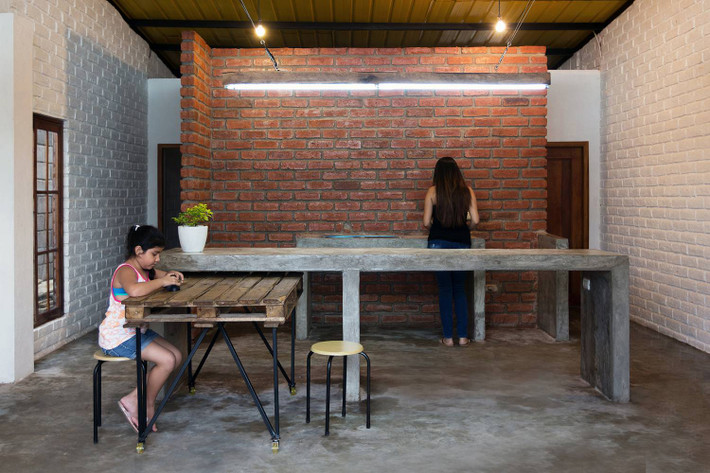Nhà bếp mộc mạc với tường gạch thô và bê tông.