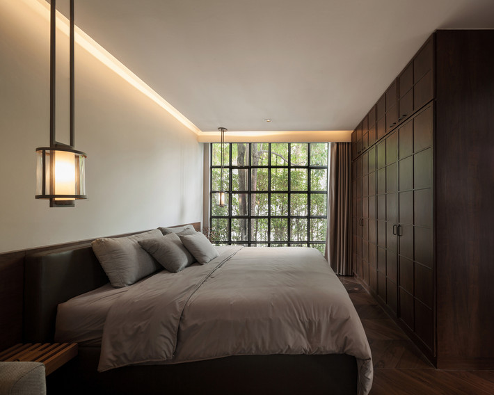 Phòng ngủ có cửa sổ kính lớn nhìn ra bên ngoài. Nguồn ảnh: Archdaily.