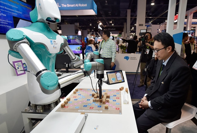 Một khách tham quan triển lãm đang cùng chơi trò ghép từ - Scabble với Robot tại CES 2018. Trí tuệ nhân tạo "đối đầu" trí tuệ con người.