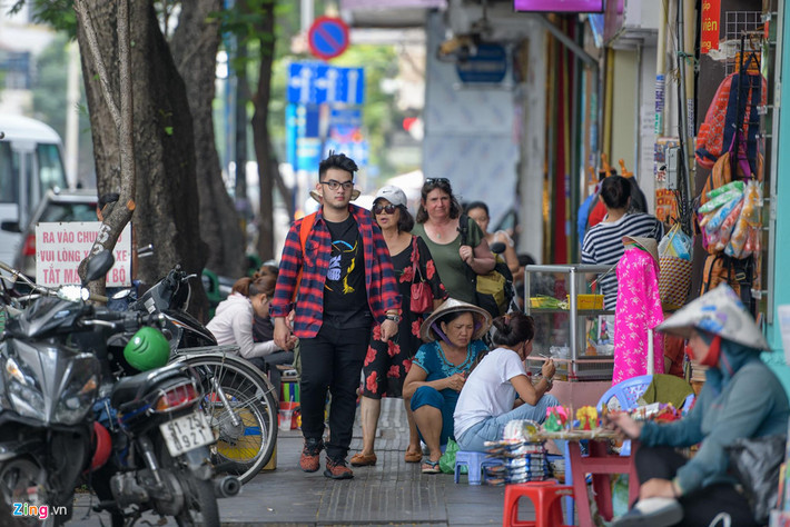 Trong khi đó, bên đường là những cửa hàng kinh doanh đồ lưu niệm, thời trang của người Việt và hàng quán vỉa hè. Con đường luôn tấp nập người dân, khách du lịch qua lại.