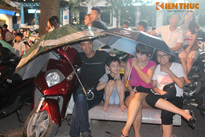 Người không có áo mưa thì che ô ngồi đợi.