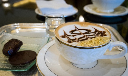 Khi đến khách sạn Emirates Palace (Abu Dhabi, UAE), du khách sẽ có cơ hội thưởng thức tách cà phê thơm dịu phủ các mảnh vàng 24 karat và chocolate. Cà phê được đặt trên một khay bạc, dùng kèm một miếng chocolate đen. Mỗi tách giá khoảng 20 USD, bao gồm cả phí dịch vụ. Ảnh: Kevinstravelblog.
