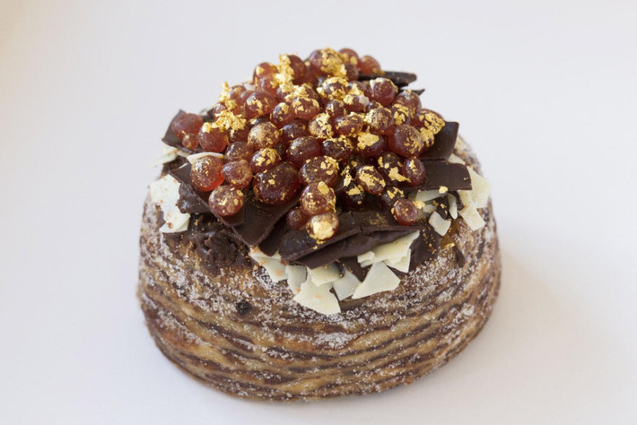 Chiếc bánh “Cronut” hay còn được gọi là “Cro” của nhà hàng Dum Dum Donutterie ở London (Anh) được làm bằng bột bánh sừng bò trộn với gia vị saffron "đắt hơn vàng ròng" (được chiết xuất từ nhuỵ hoa của cây nghệ tây), vani Tahitian và chocolate Amedei Porcelana. Sau khi nướng, bánh được phủ thêm nhiều chocolate cao cấp cùng với vàng lá và rượu champagne. Giá của một chiếc khoảng 1.950 USD. Ảnh: John Phillips/Getty Images.