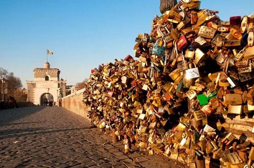 Những đôi tình nhân Italia và trên thế giới đều tin rằng, nếu khắc tên mình lên ổ khóa, sau đó treo nó vào thân một cột đèn trên cầu Milvio rồi ném chìa xuống dòng sông Tevere thì không gì có thể chia lìa được tình yêu của họ. Ảnh: Independent.