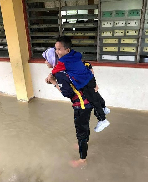 Mới đây trên mạng xã hội, những hình ảnh về một cô giáo xinh đẹp tại Malaysia không quản ngại khó khăn, cõng học sinh băng qua nước lũ khiến cộng đồng mạng vô cùng cảm động. Ảnh trong bài: Facebook nhân vật.
