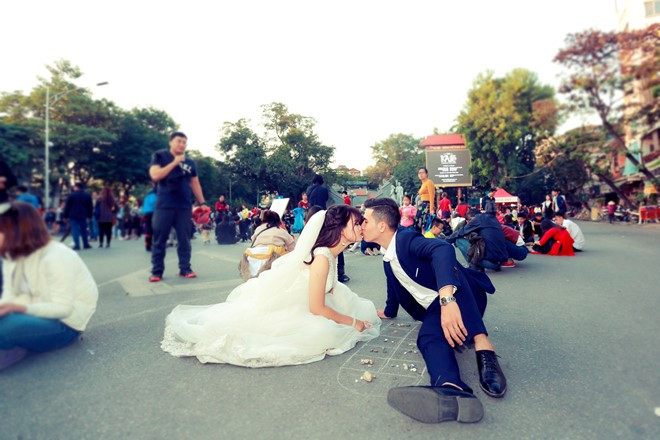 Cô dâu và chú rể thoải mái "lăn lê" để cùng chơi trò ô ăn quan, từng gắn bó với tuổi thơ của họ trong khoảng không phố đi bộ.