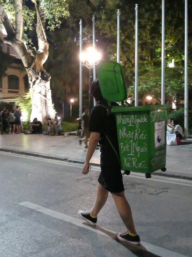 Tuy nhiên, sẽ chẳng mấy ai để ý tới hai bạn trẻ mặc đồ tối màu lặng lẽ làm công việc của những công nhân vệ sinh môi trường nếu như trên lưng họ không đeo một chiếc thùng rác màu xanh khá to. Nhất là khi trên thùng rác còn có dòng chữ mang ý nghĩa bảo vệ môi trường: “Thêm một người nhặt rác, bớt một người xả rác”.