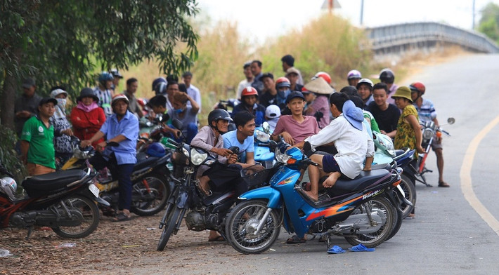 Trưa 31/1, hàng trăm người hiếu kỳ tập trung tại khu vực giáp ranh giữa xã Trung An - xã Phú Hòa Đông, huyện Củ Chi, TP.HCM. Đây là nơi hơn 500 cảnh sát được điều động vây bắt nghi can Lê Quốc Tuấn, người gây ra vụ nổ súng khiến 4 người chết tại sới bạc và 1 người chết trên đường gã này bỏ trốn.