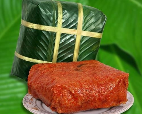 Thay vì màu xanh, lớp “áo” của bánh chưng gấc có màu đỏ au đẹp mắt. Bánh chưng gấc thơm ngậy vị gấc, nhân bánh được trộn thêm đường, thịt lợn nạc nhiều hơn so với bánh truyền thống. Ảnh: Em đẹp.