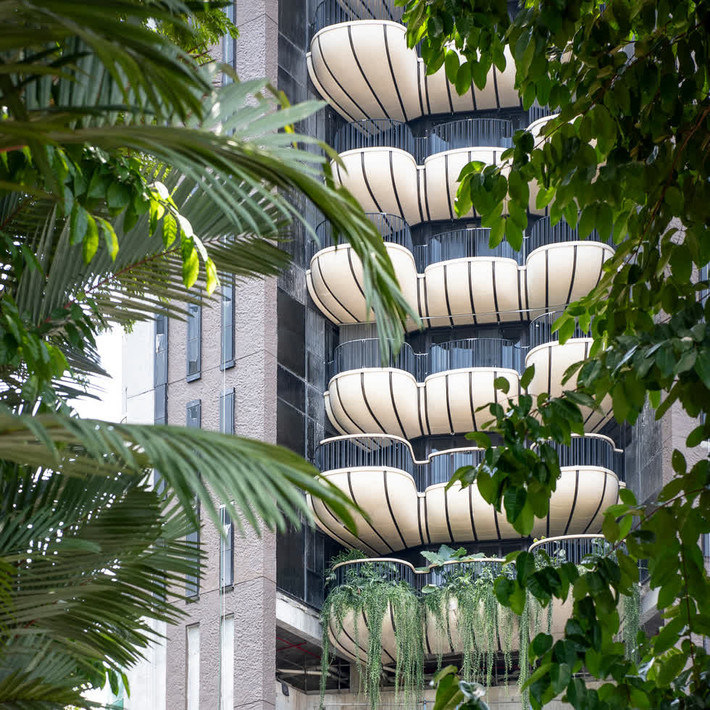 Dự án khu dân cư đầu tiên của Heatherwick Studio ở châu Á có tên là EDEN, chuẩn bị hoàn thành tại khu phố Orchard Road của Singapore. Tòa tháp bê tông cao 20 tầng gồm 20 căn hộ cao cấp phía trước có ban công cong đầy vườn treo. Nguồn ảnh: Dezeen.