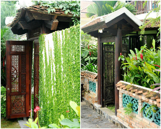 Bao quanh bởi cây xanh, hoa lá, lối vào nhà Hồng Nhung gây ấn tượng mạnh với cánh cổng gỗ chạm trổ kỳ công và mái ngói xô nghiêng. Ảnh: Vietnamnet.