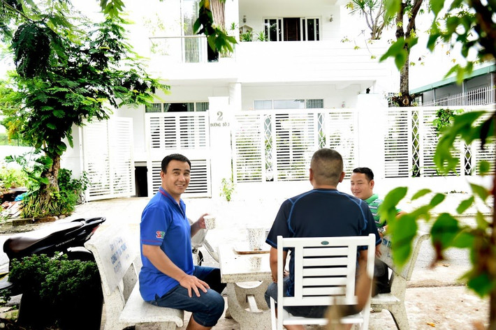 MC Quyền Linh trò chuyện với những người bạn ở bàn ghế đá ngay trước cửa nhà.