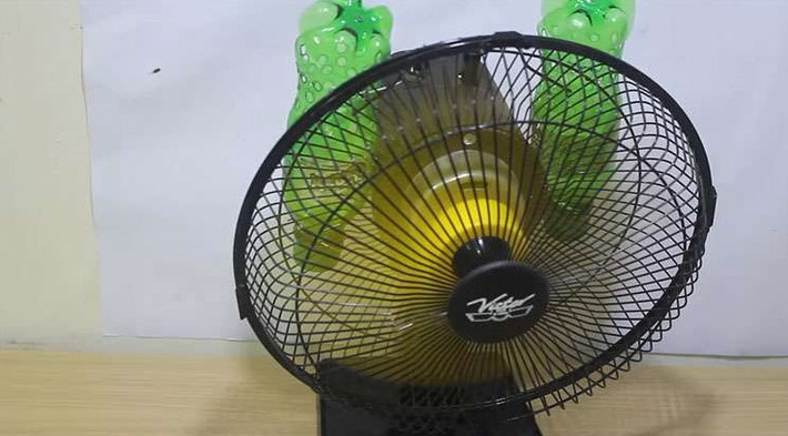 Chỉ cần cho vào hai chai một ít đá là khi bật quạt lên, một luồng gió mát lạnh sẽ được thổi ra. Ảnh: Youtube.