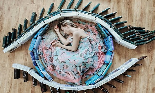 Sử dụng Instagram từ năm 2016, ban đầu Elizabeth chỉ chụp mỗi bìa sách. Tuy nhiên, khi nảy ra ý tưởng cho bản thân xuất hiện trong khung hình, cô đầu tư kỹ lưỡng hơn về chủ đề của bức ảnh, chọn màu sắc và cách xếp sách thích hợp. Bức ảnh này khiến người xem liên tưởng ngay đến một con mắt đang mở to.
