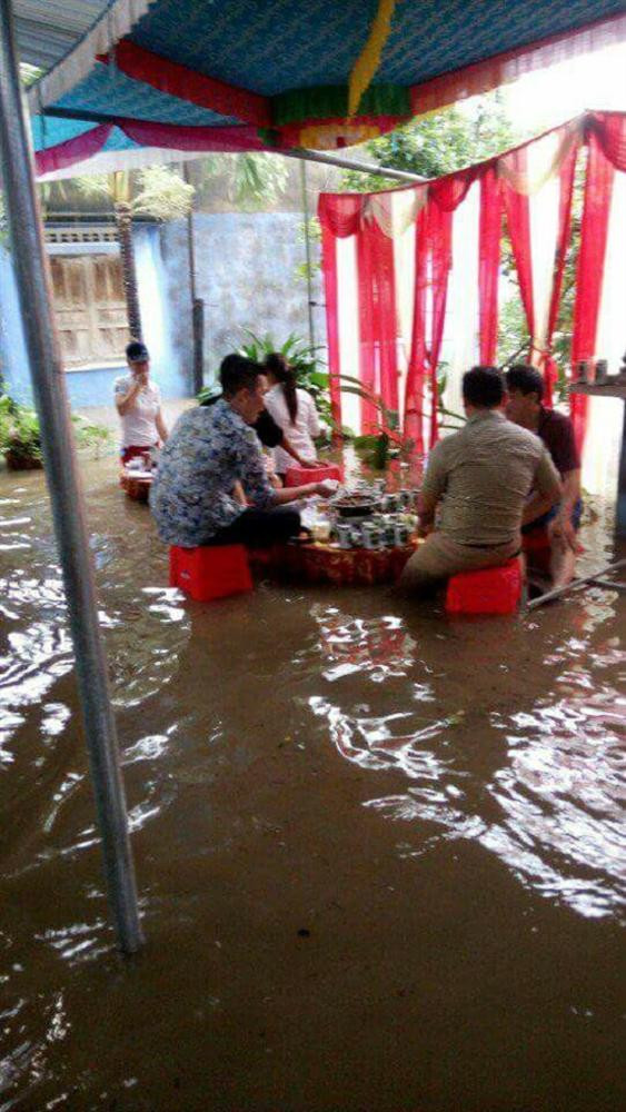Những nơi nước ngập sâu quá, người dân chồng ghế nhựa lên cao để ngồi.