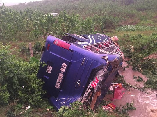 Hai nạn nhân tử vong bị xe khách đè lên trên, lực lượng chức năng đã phải điều xe cứu hộ đến hiện trường kéo chiếc xe gặp nạn lên mới có thể đưa nạn nhân ra ngoài. Nguồn ảnh: Người lao động.