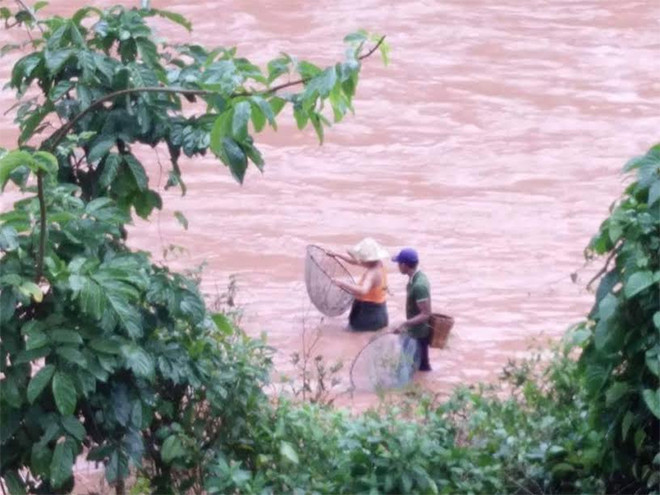 Liều mình đánh bắt cá giữa dòng nước đục ngầu, nguy hiểm. Nguồn ảnh: CAND.