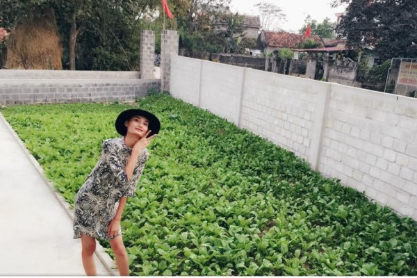 Người mẫu Lê Thúy hào hứng chụp ảnh bên vườn rau xanh mướt tại quê nhà Quảng Bình.