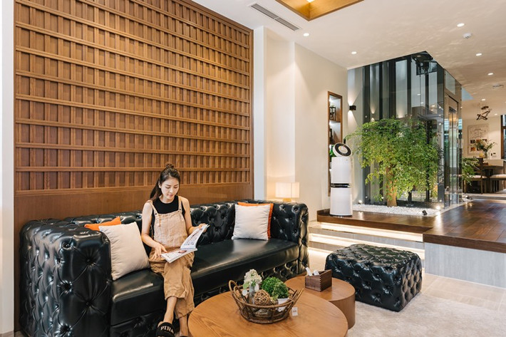 Phòng khách đặt bộ sofa màu đen sang trọng kết hợp với bàn gỗ.