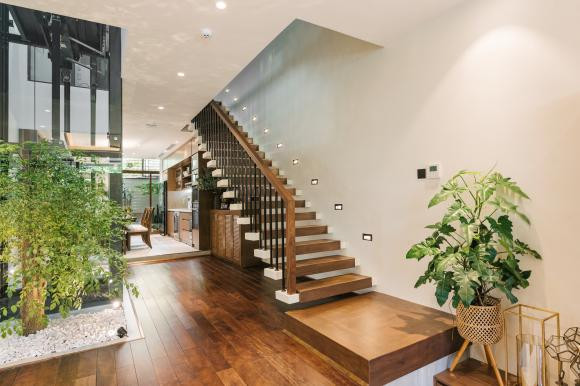 Nội thất trong nhà sử dụng tông trắng, nâu chủ đạo, điểm xuyết màu xanh của cây cối.