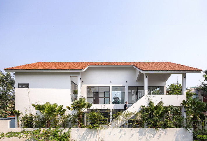 Cầu thang bay được bố trí ngoài trời như một điểm nhấn, liên kết sân chơi phía trên và phía dưới ngôi nhà. Ảnh: Triệu Chiến