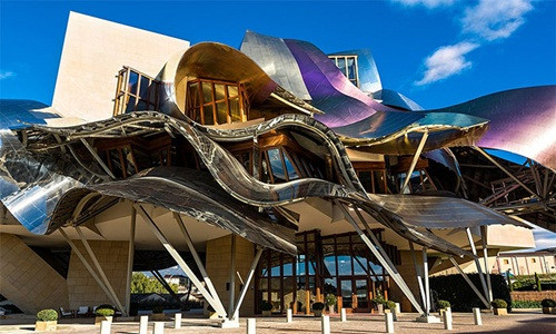 Khách sạn Marques de Riscal nằm giữa cánh đồng nho nổi tiếng Rioja thuộc xứ Basque, Tây Ban Nha khiến nhiều người liên tưởng đến dòng chảy sóng sánh tuôn ra từ những chai vang hảo hạng.