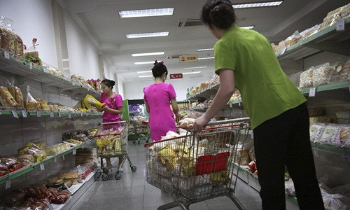 Nhân viên tại cửa hàng bách hóa Potonggang tất bật xếp đồ.