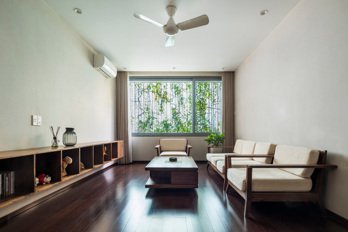 Phòng khách đơn giản, thoáng mát nhờ lớp cây bao phủ phía trước.