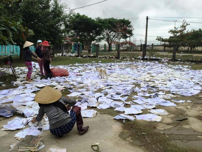 Nhiều phụ huynh nhặt sách vở ướt mang phơi tại xã Cát Chánh (huyện Phù Cát).