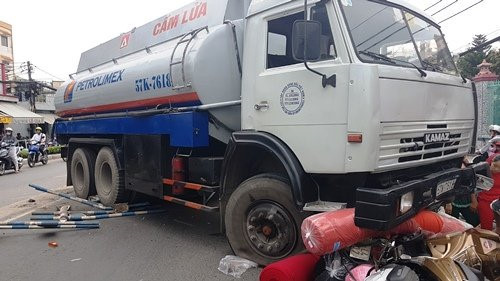 Cũng trong ngày 8/12, tại địa phận cầu Chánh Hưng, phường 10, quận 8, TP HCM, chiếc xe bồn bất ngờ húc văng hàng chục mét dải phân cách rồi lao sang làn đường bên cạnh, đâm và cuốn hai xe máy, hai người cầm lái xe máy vào gầm xe bồn. Ảnh: Vietnamnet.