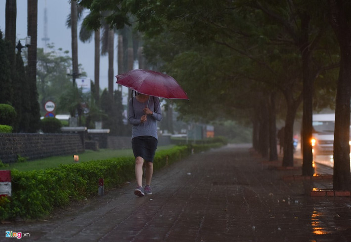 Nhiều người vội vã mặc áo mưa và bật ô.