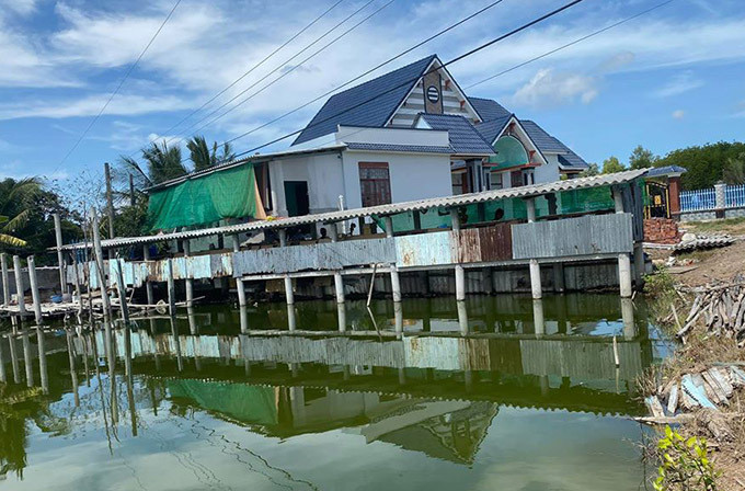 Ngoài phần đất xây nhà, Quách Ngọc Ngoan đào ao thả cá, làm chuồng trại nuôi chồn giống bán. Ảnh: FBNV