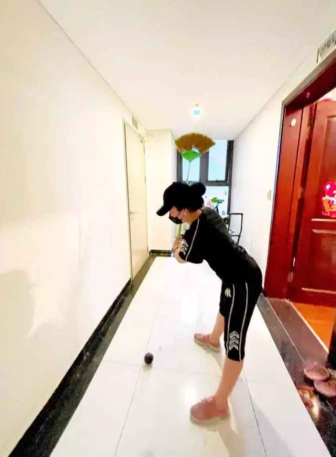 Vừa quét nhà, vừa tập chơi, động tác khom lưng, hạ đầu gối vung tay cũng rất ra dáng một golfer chuyên nghiệp.